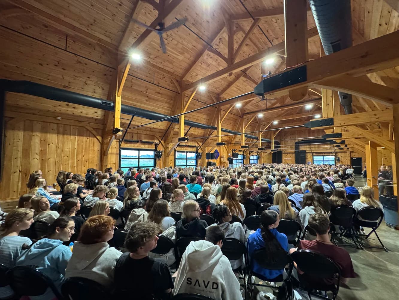 A barn packed with high school students facing the speaker at a Breakfast Club gathering